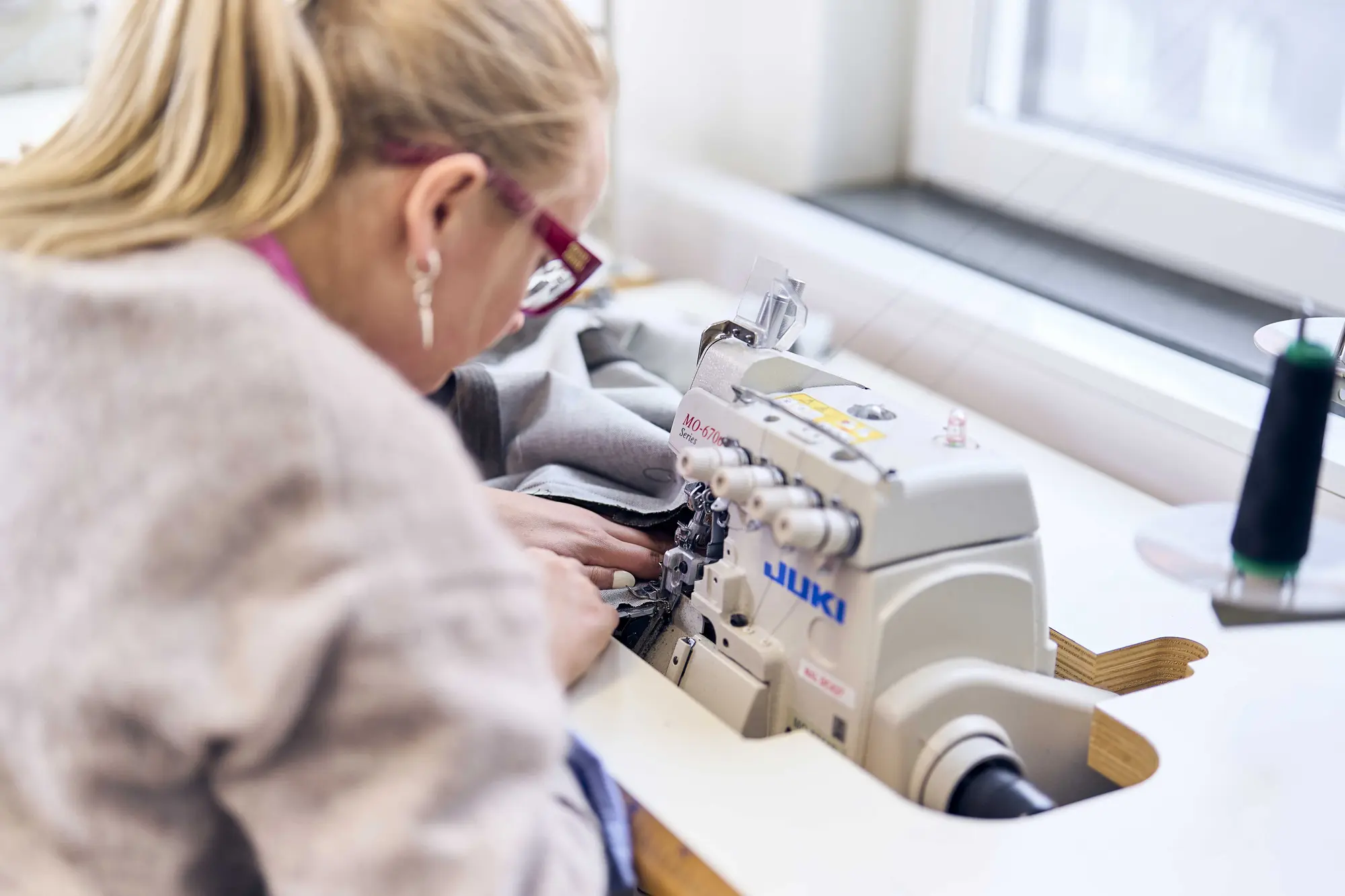 Studerande syr på symaskin